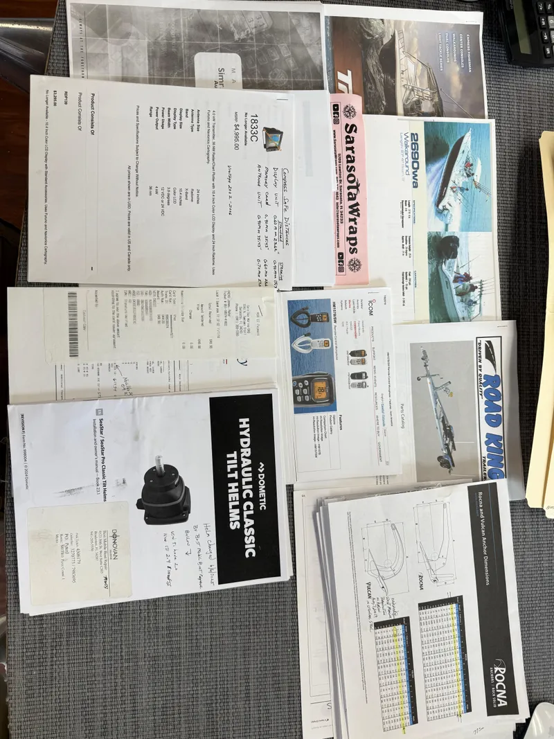 Slide: The Image of Documents and brochures for Triton 2690 WA boat, 2004 model, displayed on a table. - 41