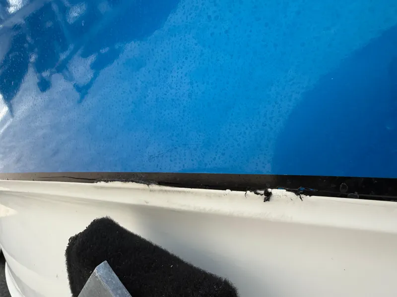 Slide: The Image of Close-up of a 2004 Triton 2690 WA boat hull with blue and white detailing. - 6