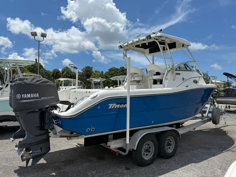 Slide: The Image of 2004 Triton 2690 WA boat on trailer with Yamaha outboard motor, under a clear blue sky. - 9