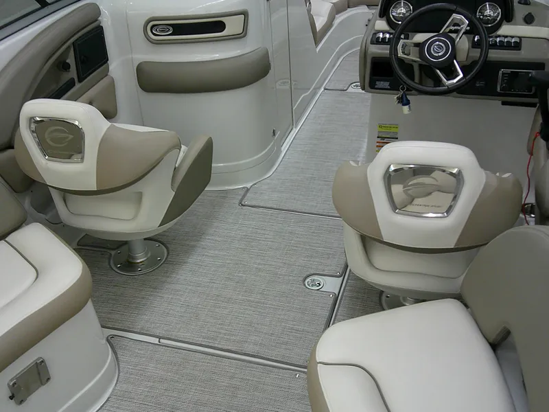 Slide: The Image of 2019 Crownline Eclipse E255 boat interior with beige seating and modern dashboard. - 11