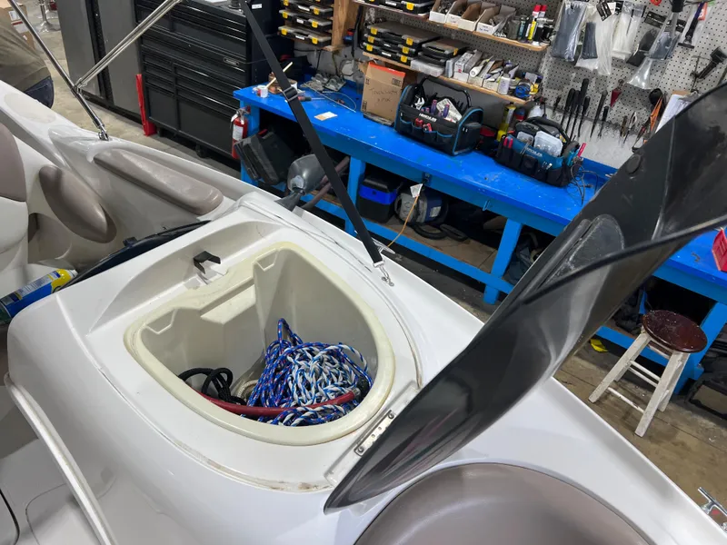 Slide: The Image of Open storage compartment of 2000 Yamaha LS 2000 boat with ropes inside, in a workshop setting. - 18