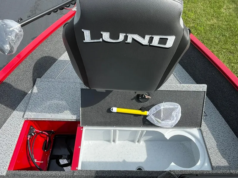 Slide: The Image of 2026 Lund 1650 Angler SS boat interior with storage compartments and fishing net. - 18