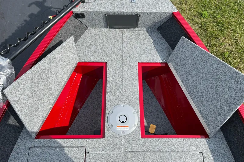 Slide: The Image of 2026 Lund 1650 Angler SS boat storage compartments with open lids, gray and red interior. - 23