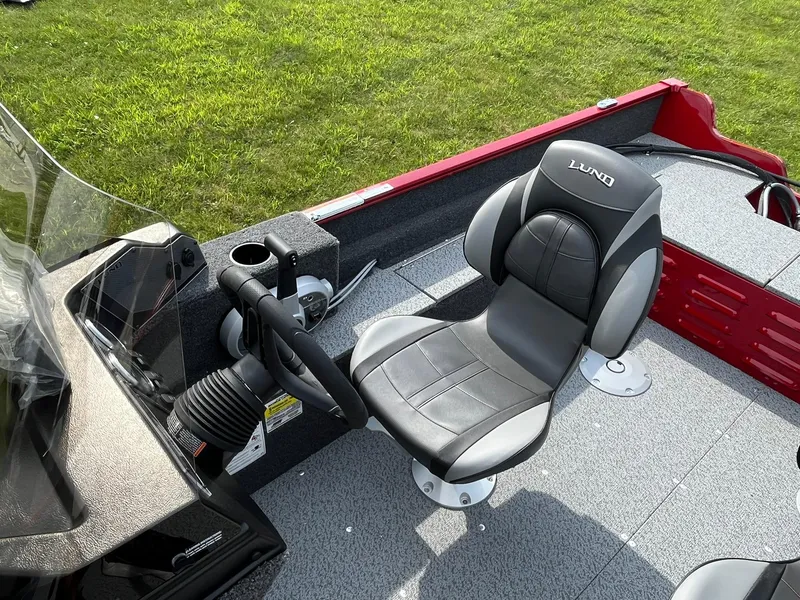 Slide: The Image of 2026 Lund 1650 Angler SS boat interior with steering wheel and cushioned seat. - 27