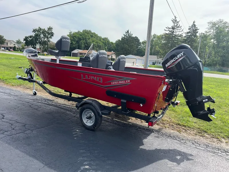Slide: The Image of 2026 Lund 1650 Angler SS boat with Mercury engine on trailer, parked outdoors. - 3