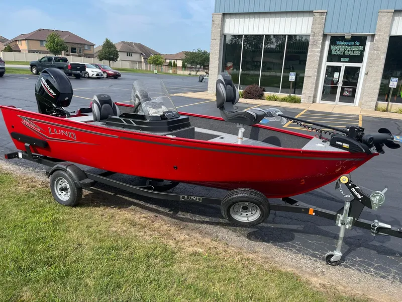 Slide: The Image of 2026 Lund 1650 Angler SS boat in vibrant red on a trailer outside a dealership. - 4