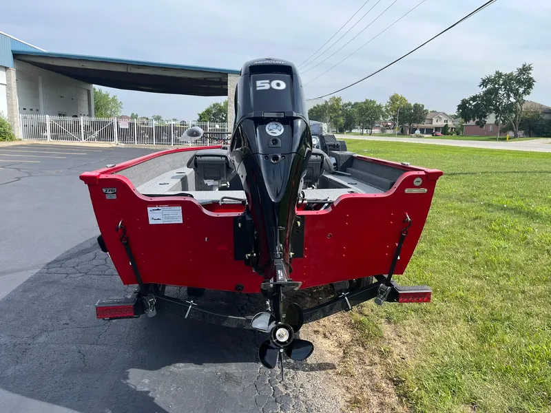 Slide: The Image of 2026 Lund 1650 Angler SS boat with 50 HP motor, parked on grass. - 41