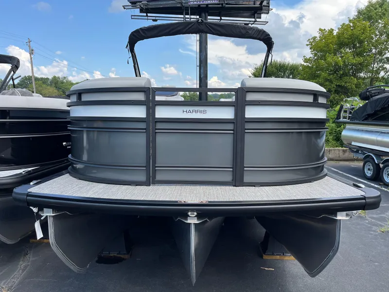 Slide: The Image of 2026 Harris Solstice 250 pontoon boat, sleek design, parked outdoors under a blue sky. - 1