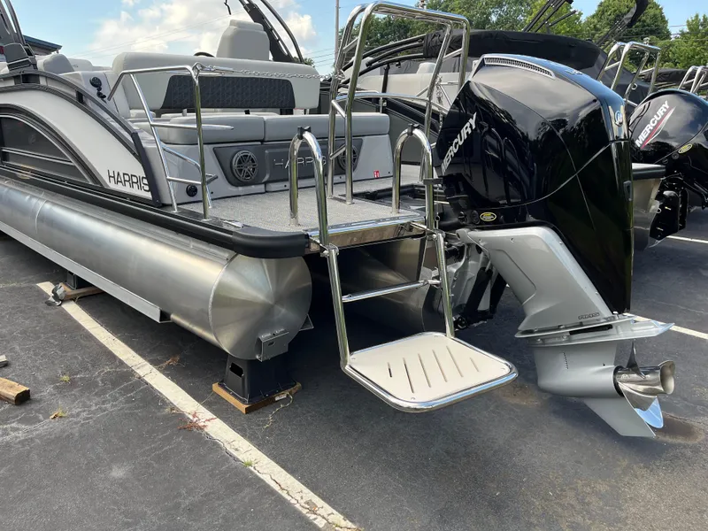 Slide: The Image of 2026 Harris Solstice 250 pontoon boat with Mercury outboard engine, docked on pavement. - 3