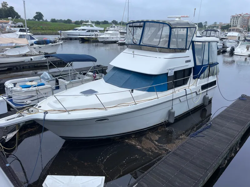 Slide: The Image of 1992 Carver 33 Aft Cabin MY docked at marina, surrounded by other boats. - 0