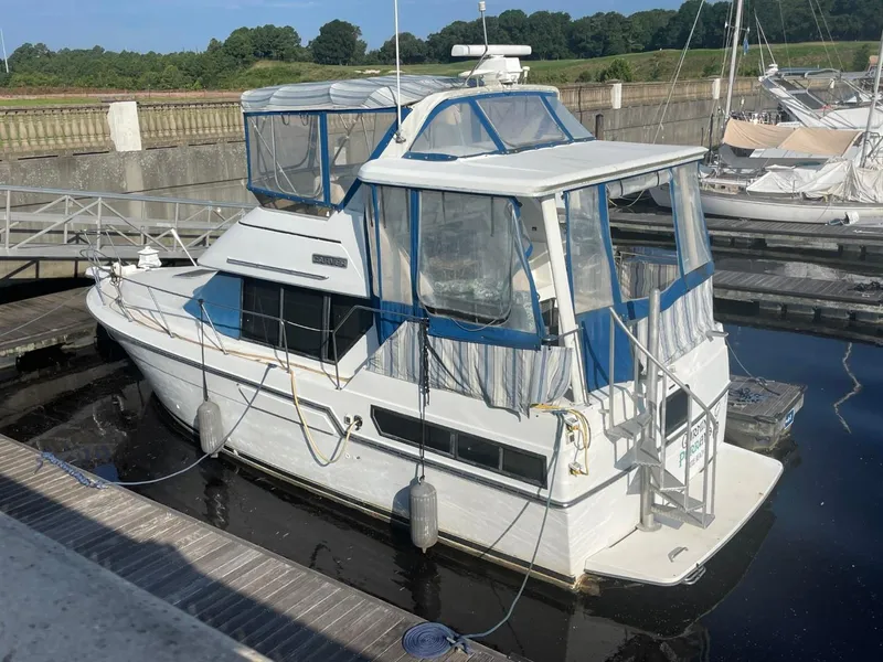 Slide: The Image of 1992 Carver 33 Aft Cabin MY docked at marina, featuring blue and white canopy. - 1