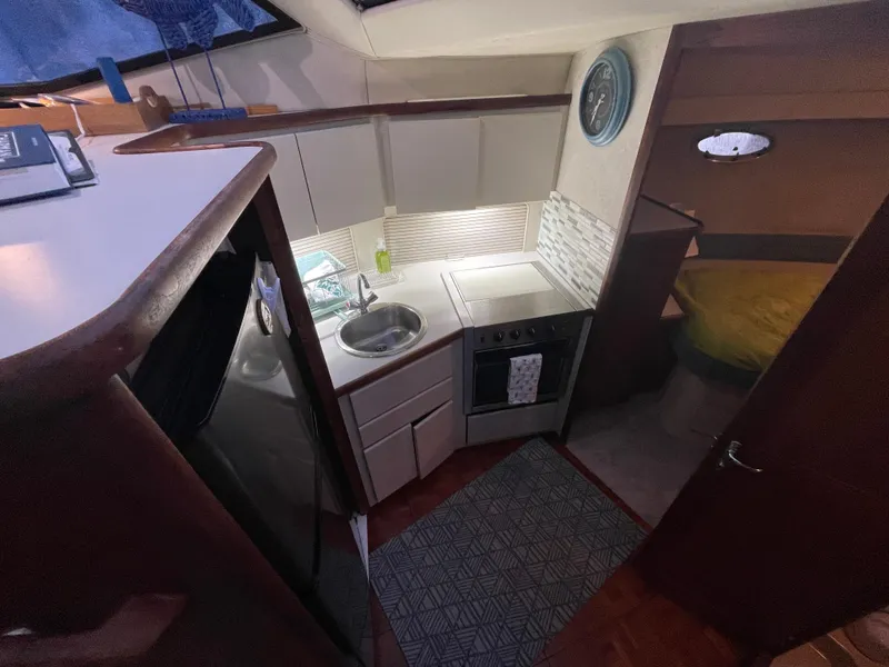 Slide: The Image of Interior of 1992 Carver 33 Aft Cabin MY, featuring compact kitchen and cozy cabin. - 17
