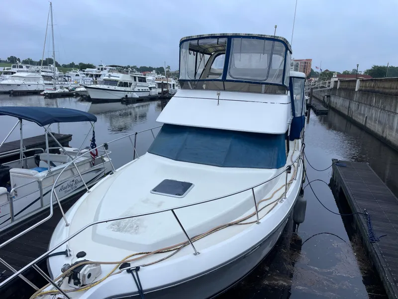 Slide: The Image of 1992 Carver 33 Aft Cabin MY docked at a marina, surrounded by other boats. - 2