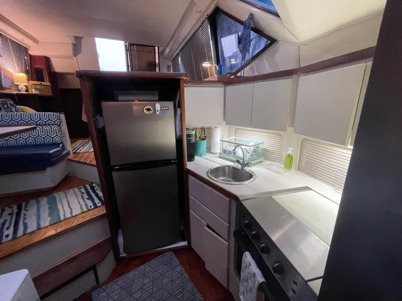 Slide: The Image of Interior of 1992 Carver 33 Aft Cabin MY, featuring kitchen with fridge and sink. - 21