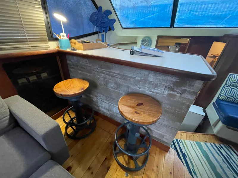Slide: The Image of Cozy interior of 1992 Carver 33 Aft Cabin MY with bar stools and wooden flooring. - 28