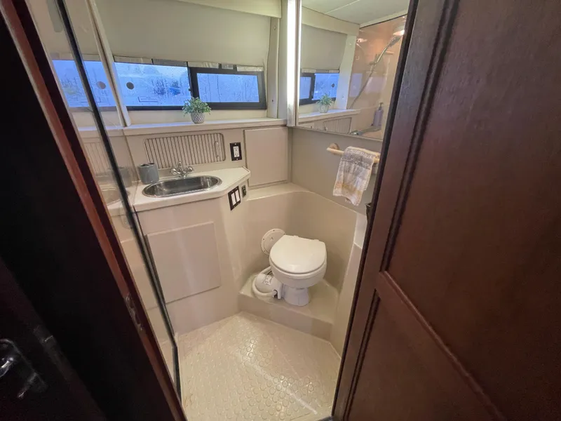 Slide: The Image of 1992 Carver 33 Aft Cabin MY bathroom with sink, toilet, and window. - 29