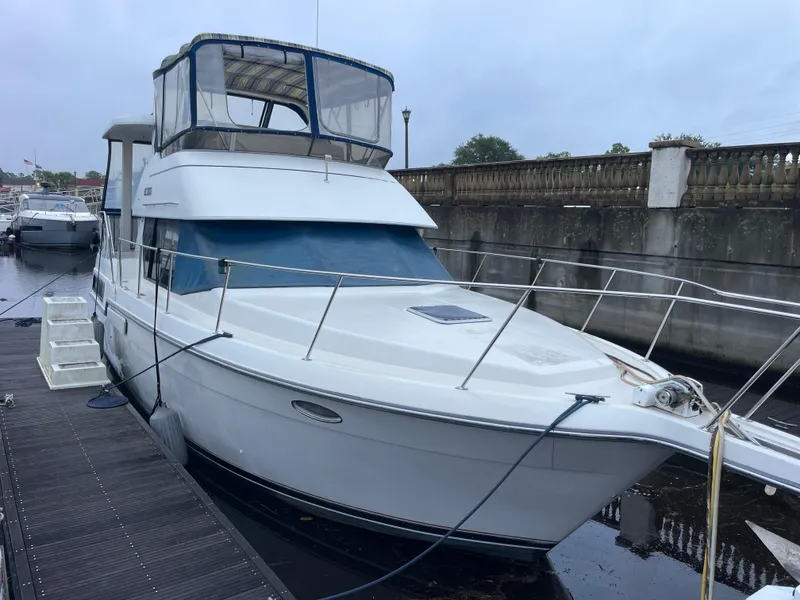 Slide: The Image of 1992 Carver 33 Aft Cabin MY docked, featuring spacious deck and enclosed flybridge. - 3