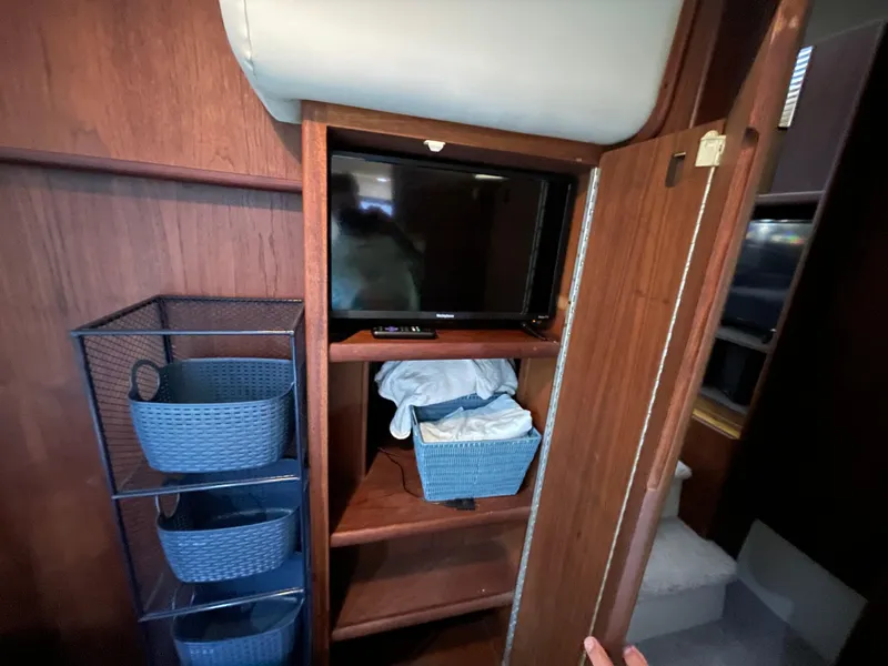Slide: The Image of 1992 Carver 33 Aft Cabin MY interior with TV, storage baskets, and wooden cabinetry. - 31