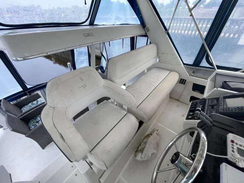 Slide: The Image of 1992 Carver 33 Aft Cabin MY interior with wicker seating and nautical decor. - 34