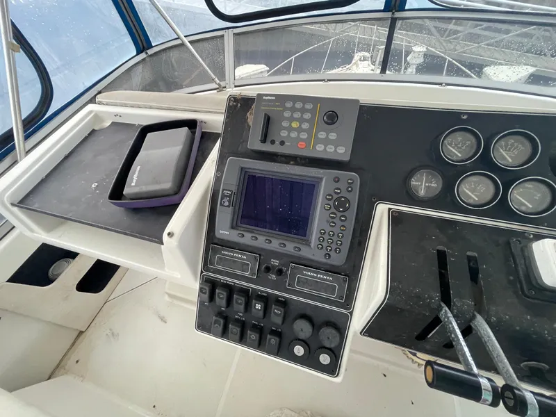 Slide: The Image of 1992 Carver 33 Aft Cabin MY helm with instruments and seating, featuring a clear view of the deck. - 36