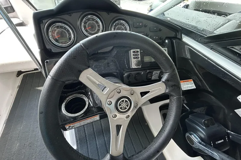 Slide: The Image of Steering wheel and dashboard of 2013 Yamaha Boats 212 X, featuring gauges and controls. - 6