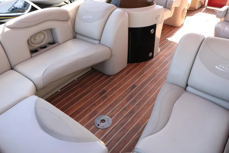 Slide: The Image of 2013 Sylvan Mirage 8522 boat interior with plush seating and wood-style flooring. - 12