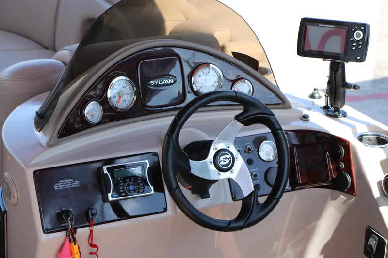 Slide: The Image of 2013 Sylvan Mirage 8522 boat interior with plush seating and modern dashboard. - 21