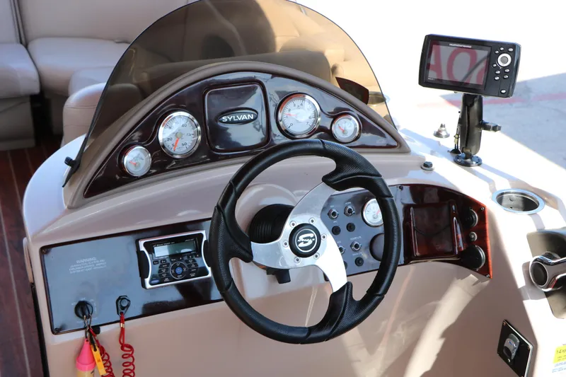Slide: The Image of Interior of 2013 Sylvan Mirage 8522 boat with beige seating and steering console. - 26