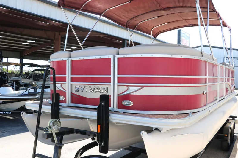 Slide: The Image of 2013 Sylvan Mirage 8522 pontoon boat with red and silver design on trailer. - 8