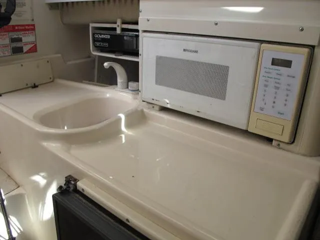 Slide: The Image of 1997 Grady-White 258 Journey boat interior with sink and microwave. - 17