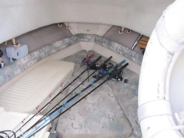 Slide: The Image of 1997 Grady-White 258 Journey cabin with fishing rods on cushioned seating. - 18