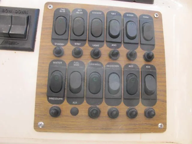 Slide: The Image of Control panel of a 1997 Grady-White 258 Journey boat with various switches. - 22
