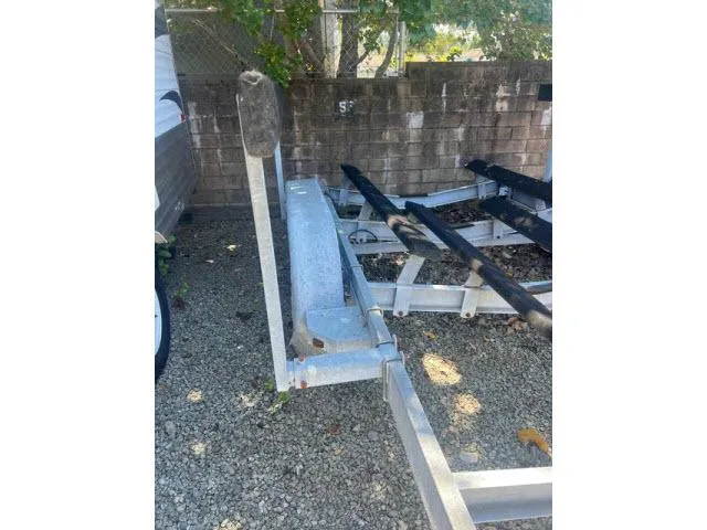 Slide: The Image of Trailer for 1997 Grady-White 258 Journey boat, parked on gravel near a brick wall. - 27