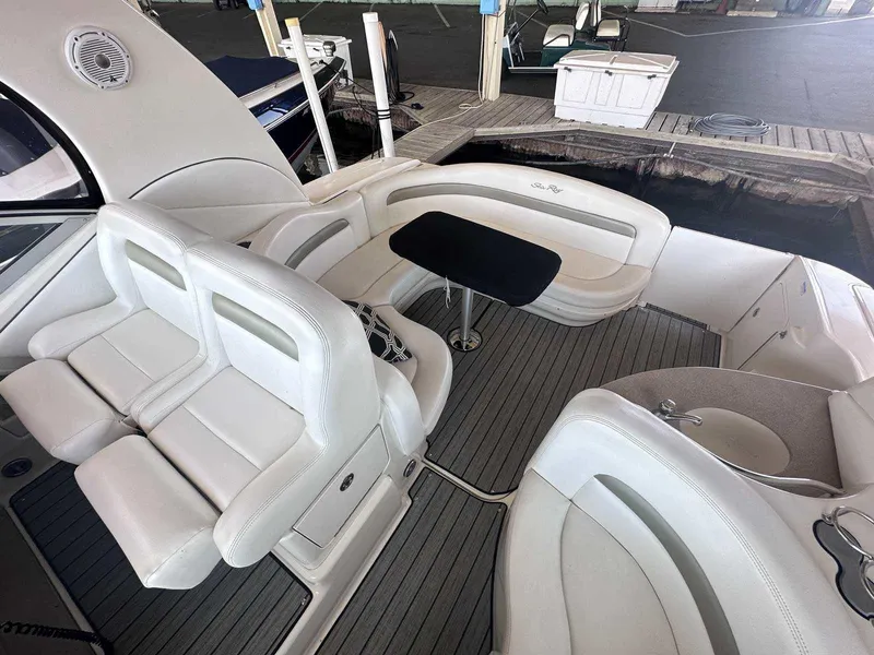 Slide: The Image of 2007 Sea Ray 320 Sundancer interior with white seating and table, docked at marina. - 14