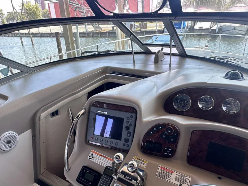 Slide: The Image of Helm of 2007 Sea Ray 320 Sundancer with navigation controls and gauges, docked at marina. - 23