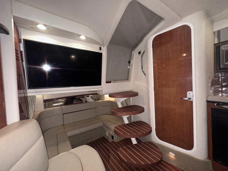 Slide: The Image of Interior of 2007 Sea Ray 320 Sundancer with TV, seating, and wooden steps. - 25