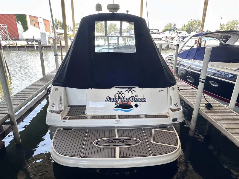 Slide: The Image of 2007 Sea Ray 320 Sundancer docked, rear view with covered cabin and "Living the Dream" decal. - 3