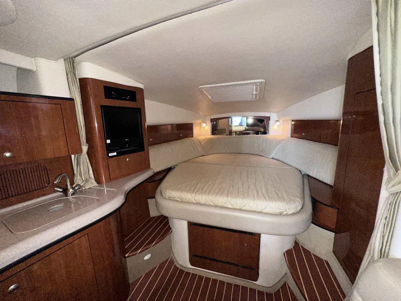 Slide: The Image of Luxurious 2007 Sea Ray 320 Sundancer cabin with bed, TV, and kitchenette. - 32