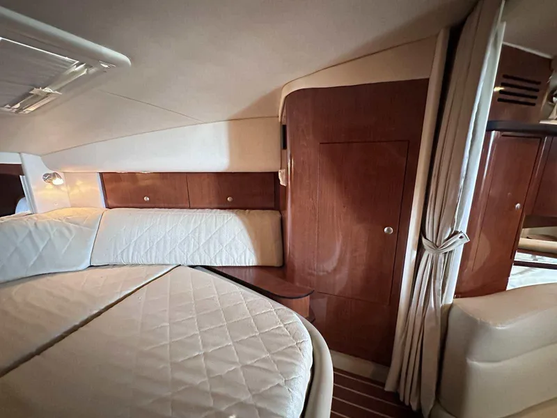 Slide: The Image of Interior cabin of 2007 Sea Ray 320 Sundancer with wood paneling and cushioned bedding. - 34