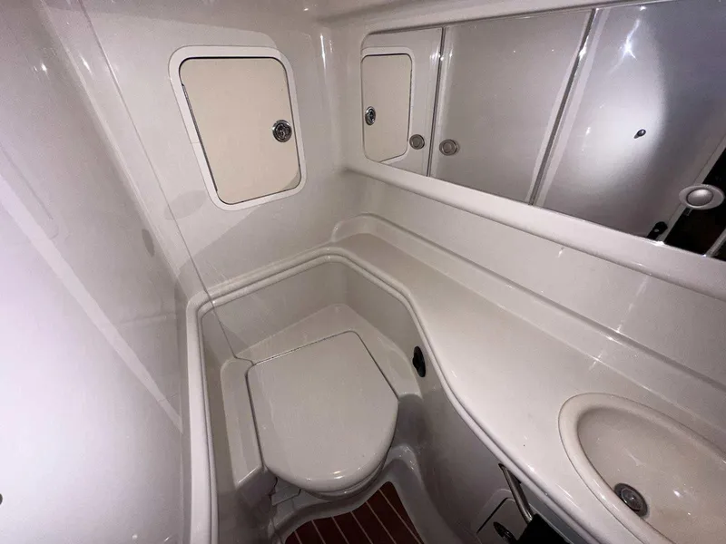 Slide: The Image of 2007 Sea Ray 320 Sundancer bathroom with compact toilet, sink, and storage cabinets. - 39