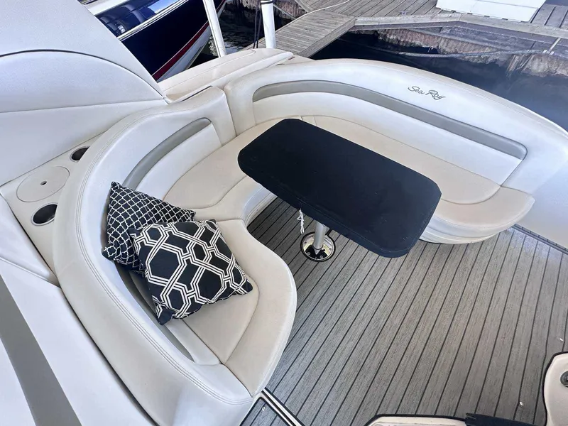 Slide: The Image of 2007 Sea Ray 320 Sundancer boat interior with cushioned seating and decorative pillows. - 7