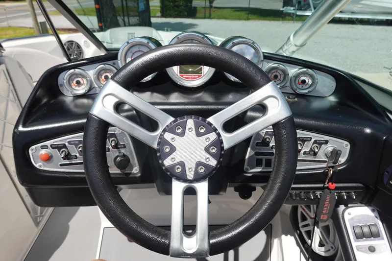 Slide: The Image of Steering wheel and dashboard of 2011 MasterCraft X15 boat, featuring gauges and controls. - 11