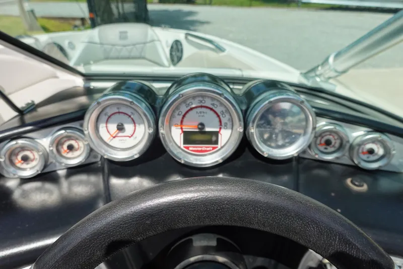 Slide: The Image of Dashboard of a 2011 MasterCraft X15 boat with multiple gauges and steering wheel. - 12