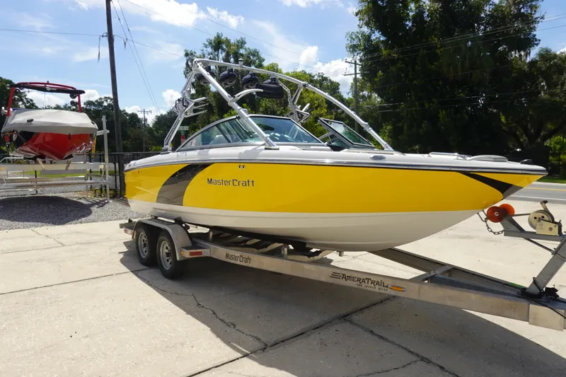 Slide: The Image of 2011 MasterCraft X15 boat in bright yellow on a trailer, parked outdoors. - 3