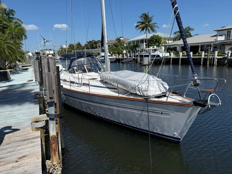 Slide: The Image of Sailboat Bavaria 44 Ocean 2003 docked in sunny marina with palm trees. - 1