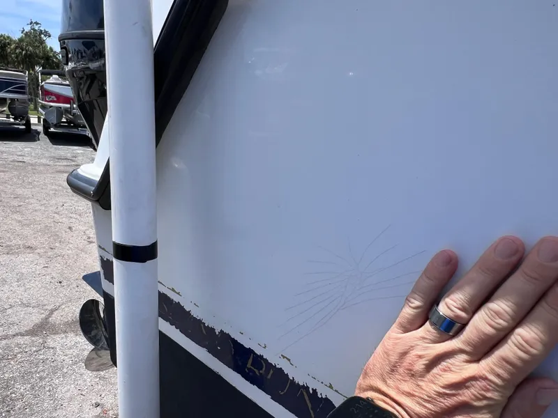 Slide: The Image of Hand inspecting scratches on 1999 Glacier Bay 2670 Island Runner boat hull. - 10