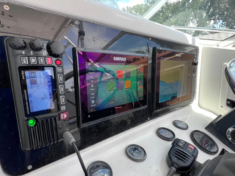 Slide: The Image of Control panel of 1999 Glacier Bay 2670 Island Runner with navigation and communication systems. - 27