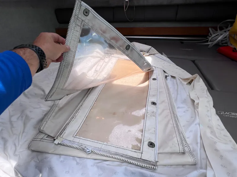 Slide: The Image of Hand inspecting boat cover on 1999 Glacier Bay 2670 Island Runner. - 43