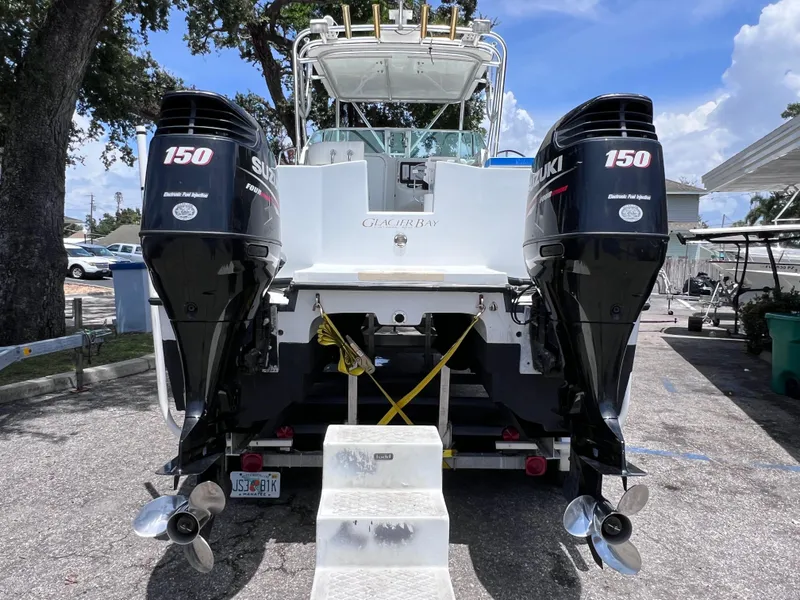 Slide: The Image of 1999 Glacier Bay 2670 Island Runner with dual Suzuki 150 engines, parked outdoors. - 5