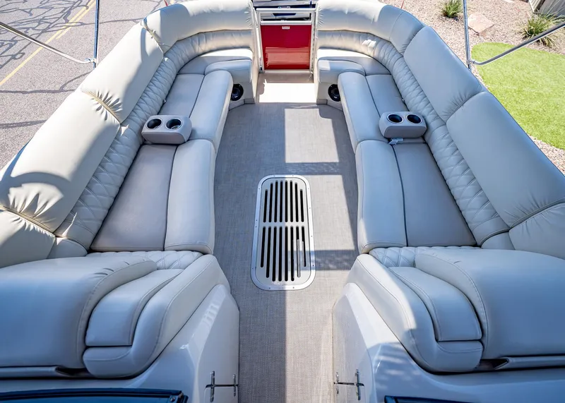 Slide: The Image of Luxurious seating on a 2015 Bennington Q28 pontoon boat, featuring plush upholstery and cup holders. - 21